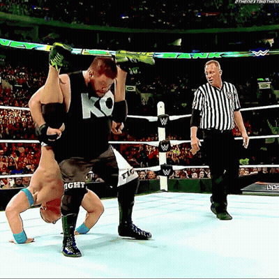 A Wrestler Wearing A Ko Tank Top Is Being Lifted In The Air GIF