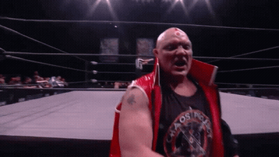 A Wrestler Wearing A Red Vest And A Black Shirt That Says Osprey GIF