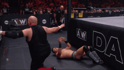 A Wrestler Wearing A Shirt That Says Chaos In Music GIF