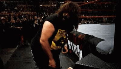 A Wrestler Wearing A Wanted Shirt Is Standing In A Ring . GIF