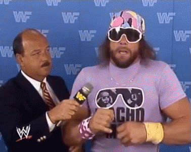 A Wrestler Wearing Sunglasses And A Purple Shirt Is Being Interviewed By A Man In A Suit And Tie . GIF