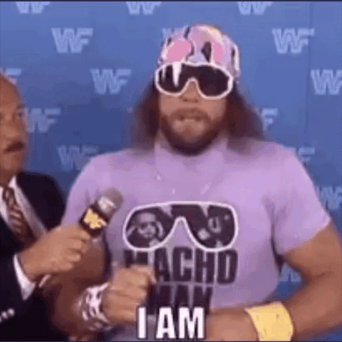 A Wrestler Wearing Sunglasses And A Purple Shirt Is Talking Into A Microphone And Saying `` I Am '' . GIF