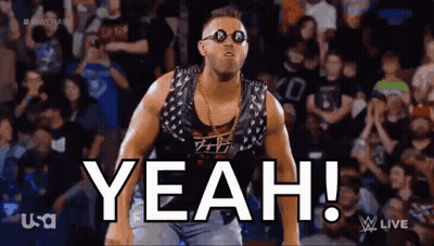 A Wrestler Wearing Sunglasses And A Vest Is Standing In Front Of A Crowd And Says Yeah . GIF