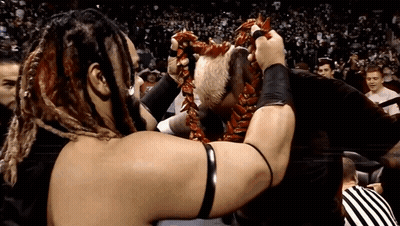 A Wrestler With Dreadlocks Is Holding A Lei Around His Head GIF