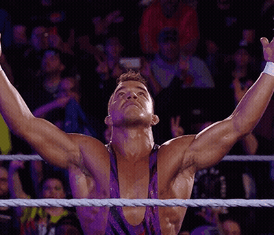 A Wrestler With His Arms Outstretched In The Air GIF