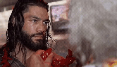 A Wrestler With Long Hair And A Beard Is Holding A Red Object . GIF