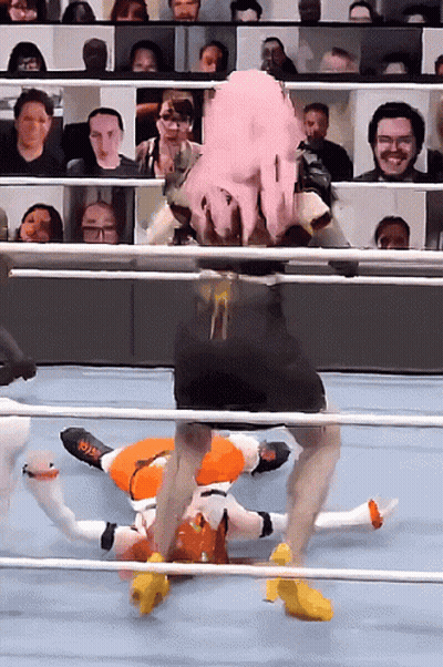 A Wrestler With Pink Hair Is Laying On The Ground In A Ring GIF