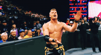 A Wrestler With The Word Waller On His Shorts Stands In Front Of A Crowd GIF