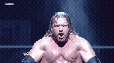 A Wrestler Without A Shirt Is Standing In Front Of A Wwe Logo GIF