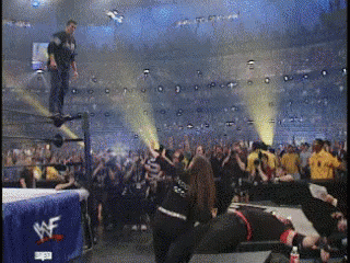 A Wrestling Match Is Being Played In A Stadium With A Wwe Banner In The Background GIF