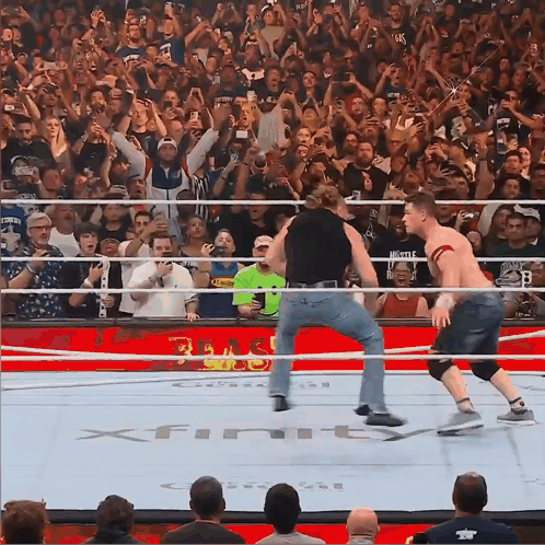 A Wrestling Match Is Being Played In Front Of A Crowd That Is Watching GIF