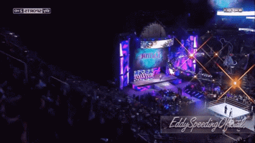 A Wrestling Match Is Being Shown On A Large Screen And The Words Eddy Speeding Official Are On The Bottom Right GIF
