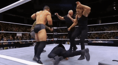 A Wrestling Match Is Going On In A Ring With A Crowd Watching . GIF