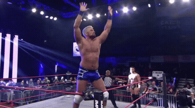 A Wrestling Ring With A Referee And A Sign That Says Catch 'Em GIF