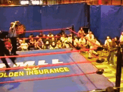 A Wrestling Ring With A Sign That Says " Golden Insurance " GIF