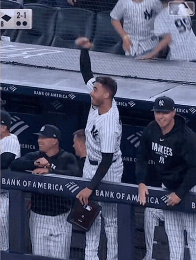 A Yankees Baseball Player Stands In The Dugout With His Hand In The Air GIF