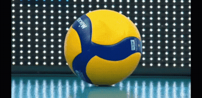 A Yellow And Blue Mikasa Volleyball Is Sitting On The Floor GIF