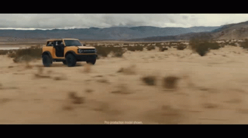 A Yellow Bronco Is Driving Through A Desert GIF