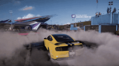 A Yellow Car Is Drifting In Front Of A Sign That Says Festival Depost GIF