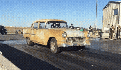 A Yellow Car Is Driving Down A Race Track With The Number 14X On The Windshield GIF
