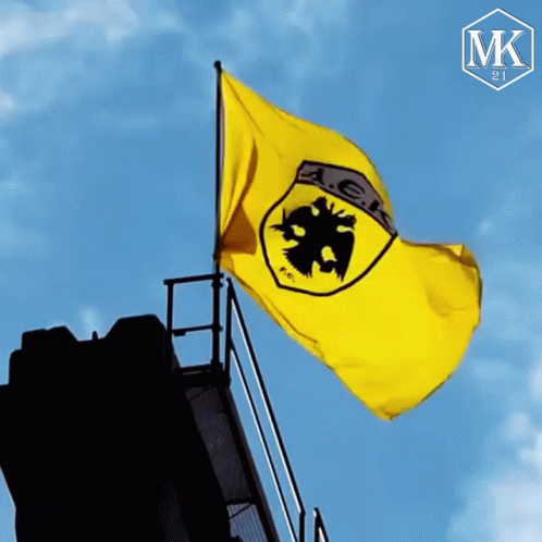 A Yellow Flag With A Black Eagle And The Letter Ak On It GIF