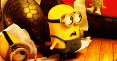 A Yellow Minion Is Standing On A Wooden Floor Next To A Ball GIF