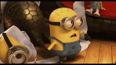 A Yellow Minion Wearing Goggles Is Standing On A Wooden Floor GIF