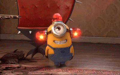 A Yellow Minion Wearing Overalls Has A Red Light On His Head GIF