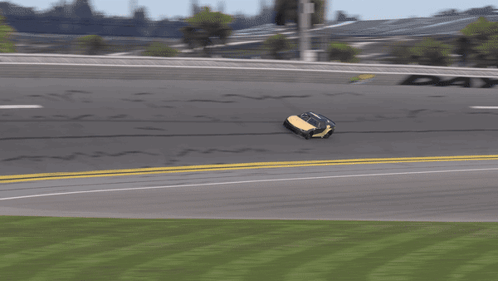 A Yellow Race Car Is Driving Down A Race Track GIF