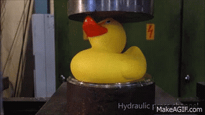 A Yellow Rubber Duck With A Red Beak Is Being Pressed Under A Hydraulic Press GIF