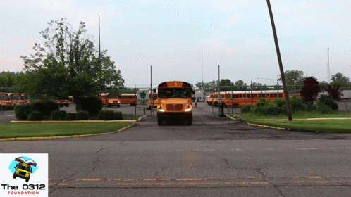 A Yellow School Bus Is Parked In A Parking Lot With The Foundation Logo In The Corner GIF