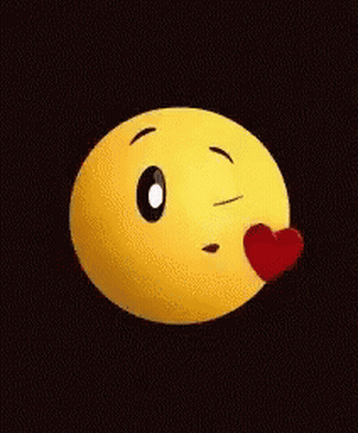 A Yellow Smiley Face Is Blowing A Kiss With A Red Heart On Its Nose . GIF