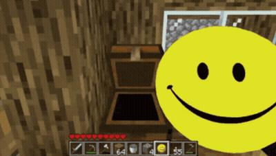 A Yellow Smiley Face Is In Front Of A Wooden Chest In A Video Game GIF