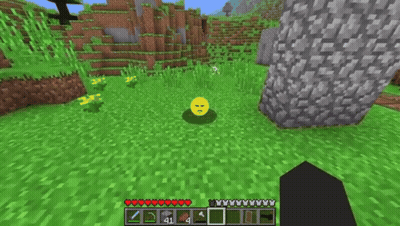 A Yellow Smiley Face Is Sitting In The Grass In A Minecraft World GIF