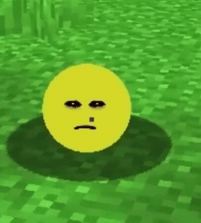 A Yellow Smiley Face With A Tooth Is Sitting In The Grass . GIF