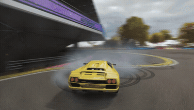 A Yellow Sports Car Is Drifting On A Track With Smoke Coming Out Of The Tires GIF