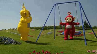 A Yellow Teddy Bear And A Red Teddy Bear Standing Next To A Swing Set GIF