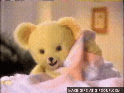 A Yellow Teddy Bear Is Laying On A Bed With A Make Gifs At Gifsoup.com Button GIF