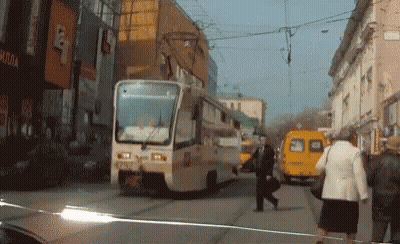 A Yellow Van Is Parked On The Side Of The Road In Front Of A Building That Says ' Apollo ' GIF