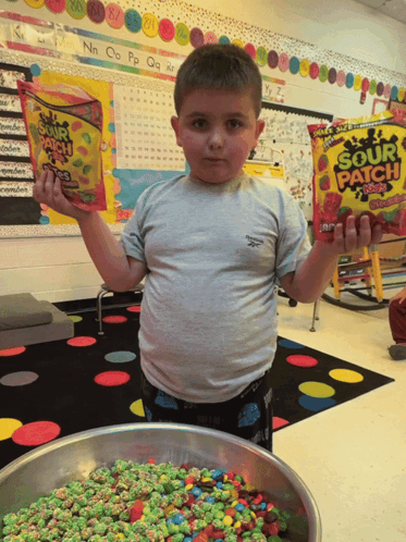 A Young Boy Holding A Bag Of Sour Patch Kids GIF