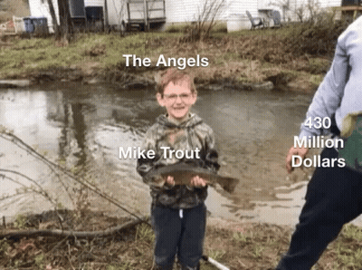 A Young Boy Holding A Fish In Front Of A River With The Words The Angels Mike Trout 430 Million Dollars On The Bottom GIF
