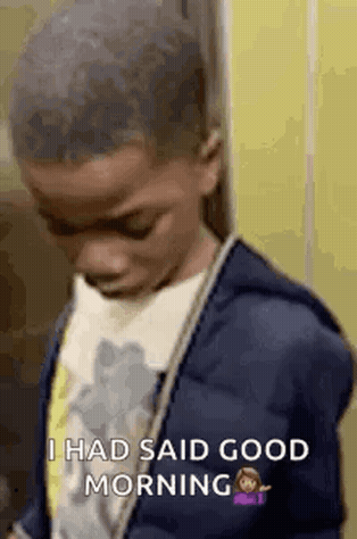 A Young Boy In A Blue Jacket Is Standing In Front Of A Yellow Wall And Says `` I Had Said Good Morning '' . GIF