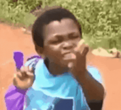 A Young Boy In A Blue Shirt Is Holding A Purple Bag And Blowing A Kiss . GIF