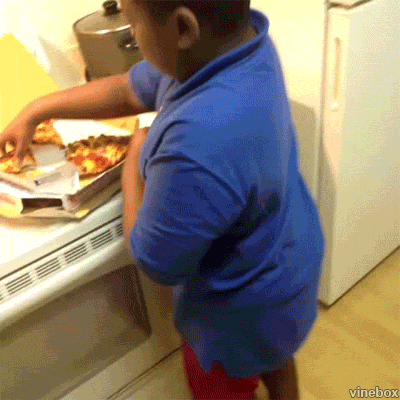 A Young Boy In A Blue Shirt Is Reaching For A Pizza Box GIF
