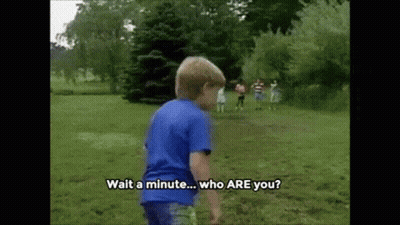 A Young Boy In A Blue Shirt Is Standing In A Grassy Field And Says Wait A Minute Who Are You GIF
