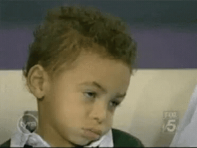 A Young Boy In A Bow Tie Is Making A Funny Face . GIF