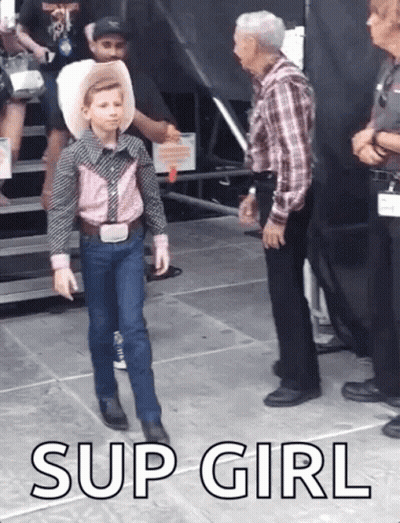 A Young Boy In A Cowboy Outfit Is Standing Next To An Older Man With The Words Sup Girl Below Him GIF