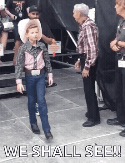 A Young Boy In A Cowboy Outfit Is Walking On A Stage With The Words " We Shall See " Above Him GIF