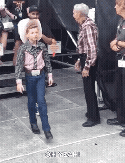 A Young Boy In A Cowboy Outfit Is Walking Towards An Older Man Who Says Oh Yeah . GIF