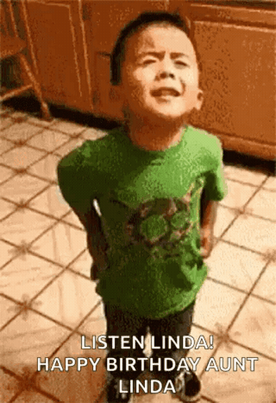 A Young Boy In A Green Shirt Is Standing On A Tiled Floor And Making A Funny Face . GIF